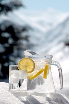 clean water in a pitcher with lemons, sitting in snow